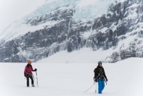 Paar spaziert im Winter mit Geschirr auf einem schneebedeckten Berg — Stockfoto