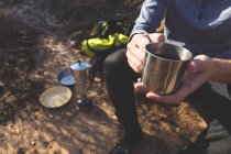 Мужчина-турист пьет кофе в сельской местности в солнечный день — стоковое фото