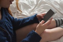 Frau benutzte Handy im Schlafzimmer — Stockfoto
