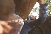 Escursionista maschio arrampicata montagna rocciosa in campagna — Foto stock