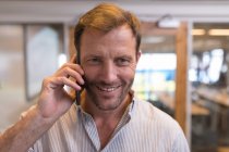 Esecutivo maschio che parla al cellulare in ufficio — Foto stock