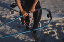 Surfista maschio che prepara un aquilone su una spiaggia al crepuscolo — Foto stock