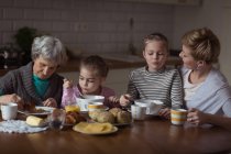 Multi-generation family having breakfast in kitchen at home — Stock Photo
