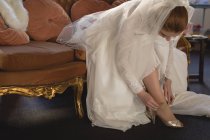 Braut im Brautkleid mit High Heels in Boutique — Stockfoto