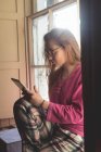 Jeune femme utilisant une tablette numérique à la maison — Photo de stock