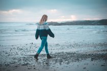 Nachdenkliche Frau geht am Strand spazieren — Stockfoto