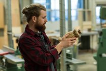 Carpentiere maschio attento che esamina un mobile di legno a workshop — Foto stock