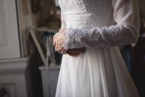Seção média de noiva em vestido de noiva em pé no quarto — Fotografia de Stock