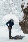 Чоловічий альпініст у взутті біля скелястої гори взимку — стокове фото
