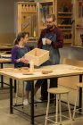 Menuisiers et menuisières discutant de meubles en bois à l'atelier — Photo de stock