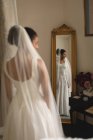 Riflessione della giovane sposa in abito da sposa a specchio — Foto stock