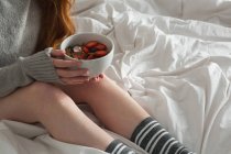 Женщина держит миску с завтраком в спальне дома — стоковое фото