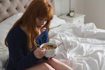Frau frühstückt zu Hause im Schlafzimmer — Stockfoto