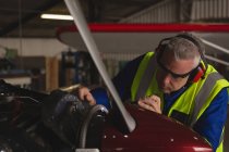 Ingeniero de reparación de motores de aviones en hangar - foto de stock