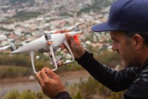 Primer plano del hombre sosteniendo un dron volador - foto de stock