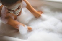Жінка приймає бульбашкову ванну в ванній вдома — стокове фото