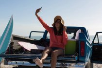 Donna scattare selfie con il telefono cellulare in un pick-up in spiaggia — Foto stock