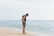 Hombre de pie en la playa - foto de stock