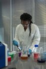 Вчений піпеточні рішення в пробірці скла в лабораторії — стокове фото