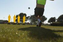 Гравець ногами футбол в галузі спорту на сонячний день — стокове фото