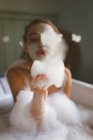 Mulher brincando com espuma no banheiro em casa — Fotografia de Stock