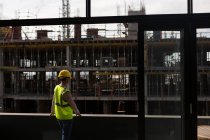 Вид ззаду на жіночого архітектора, що стоїть на будівельному майданчику — стокове фото