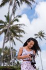 Молода жінка оглядає фотографії на цифровій камері на пляжі — стокове фото