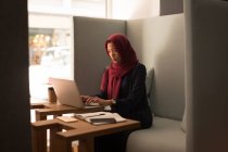 Donna d'affari in hijab utilizzando il computer portatile in mensa ufficio — Foto stock