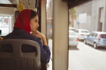 Hermosa mujer hijab mirando a través de la ventana en el autobús - foto de stock
