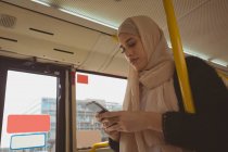 Belle femme hijab utilisant le téléphone portable dans le bus — Photo de stock