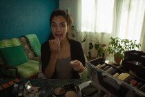 Mujer video blogger aplicando crema en los labios en casa - foto de stock