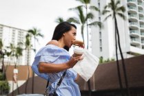 Beautiful woman having breakfast on street — Stock Photo
