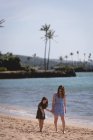 Мати і дочка гуляють разом на пляжі в сонячний день — стокове фото
