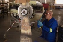 Ingenieur überprüft Flugzeugteile in Aufhängung — Stockfoto