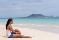 Молода жінка розслабляється на пляжі — стокове фото