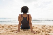 Вид ззаду жінки, що розслабляється на пляжі — стокове фото
