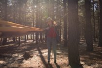 Frau bindet Hängemattengurt an Baum im Wald — Stockfoto