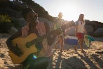 Mulher tocando guitarra na praia em um dia ensolarado — Fotografia de Stock