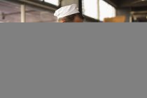 Зріла чоловіча пекарня тримає лоток півмісячних рулонів в хлібопекарні — стокове фото