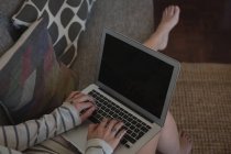 Низька частина жінки, використовуючи ноутбук вдома — стокове фото