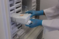 Cientista que toma o tubo de ensaio do congelador no laboratório — Fotografia de Stock