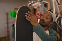 Uomo che fa skateboard in officina — Foto stock