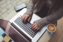 Seção média de mulher usando laptop no café — Fotografia de Stock