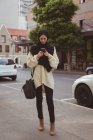 Красива міська хіджаб жінка використовує мобільний телефон на тротуарі — стокове фото
