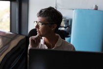 Thoughtful mature businesswoman looking away in the office — Stock Photo