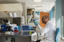 Ученый проверяет химический раствор в лаборатории — стоковое фото