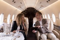 Gli uomini d'affari discutono su tablet digitale in jet privato — Foto stock