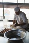 Зріла чоловіча пекарня готує тісто в хлібопекарні — стокове фото