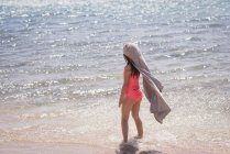 Ragazza che gioca in acqua in spiaggia in una giornata di sole — Foto stock