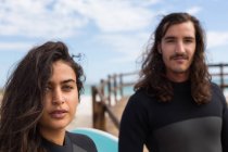 Retrato de casal de surfistas juntos na praia — Fotografia de Stock